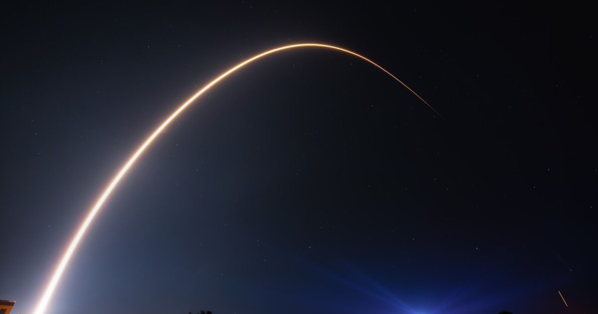 SpaceX Falcon 9 rocket arcing through night sky carrying Starlink satellites
