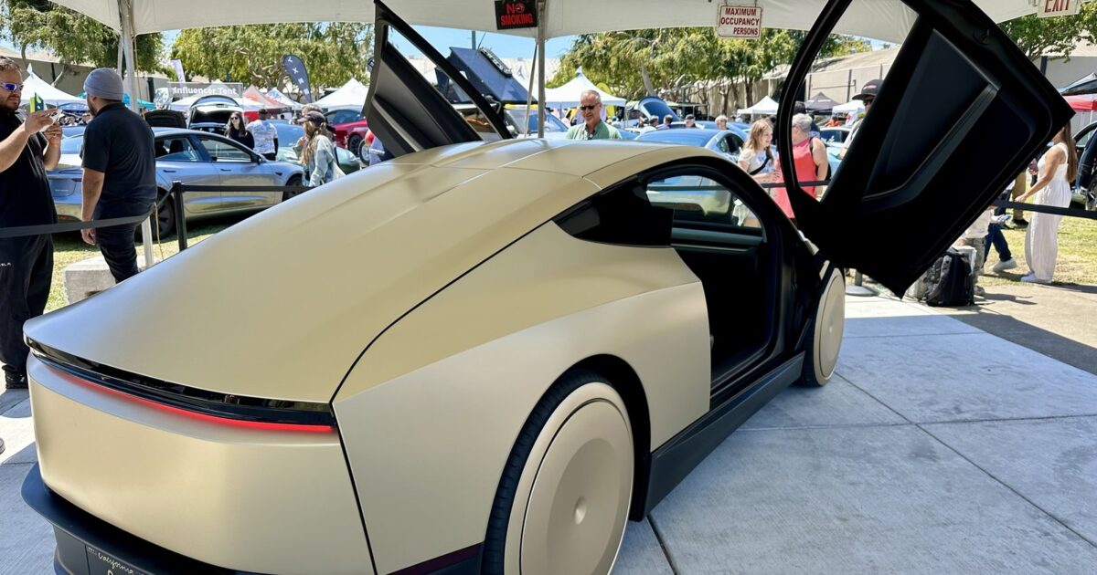 Gold Tesla Cybercab with butterfly doors open on display at the X Takeover event in San Mateo