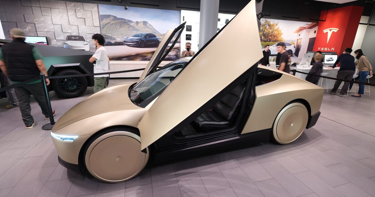 Tesla Cybercab in gold with butterfly door open inside a Tesla showroom