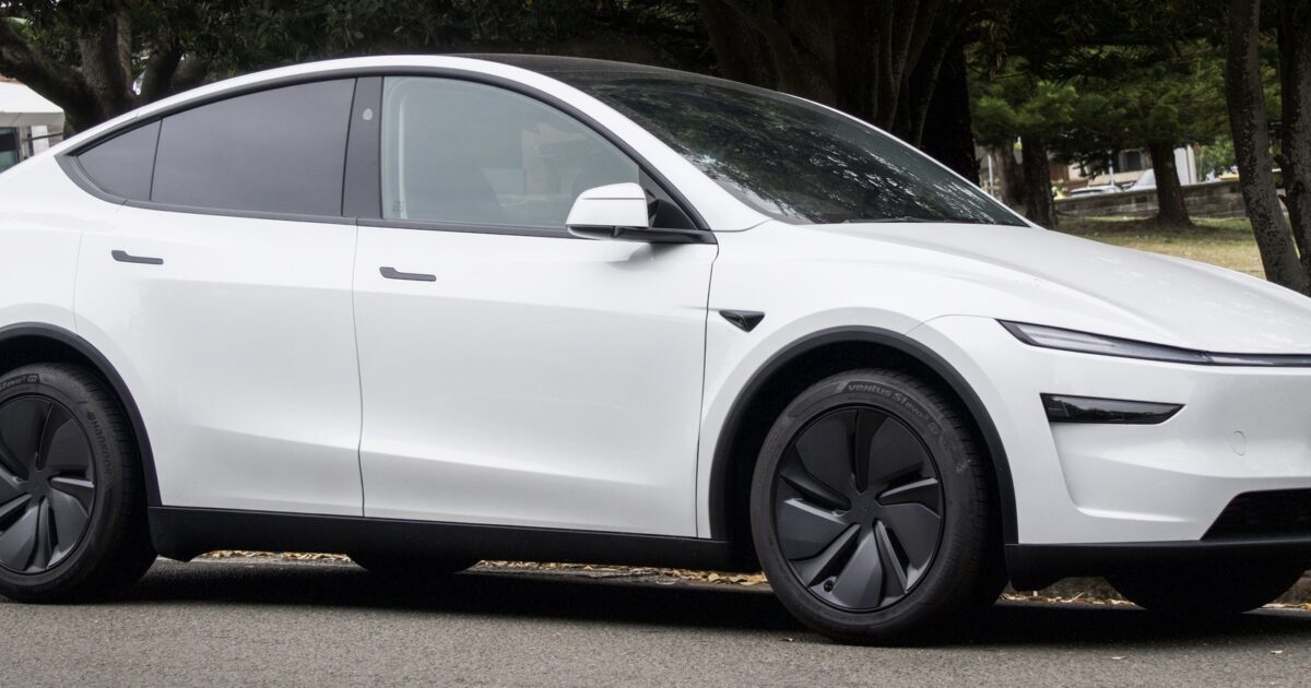 White 2025 Tesla Model Y Juniper showing the refreshed exterior design with full-width lightbar