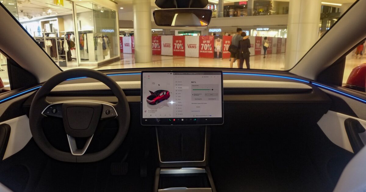 Tesla Model Y Juniper interior showing touchscreen with vehicle visualization and ambient lighting
