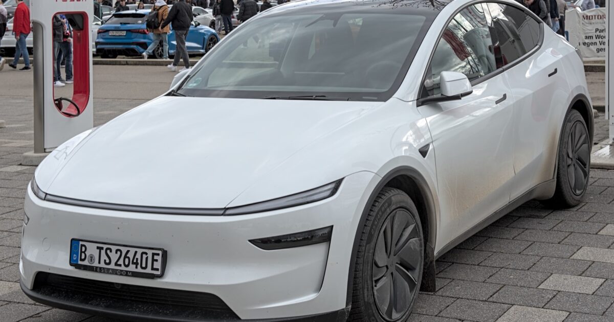 Tesla Model Y parked near a Tesla Supercharger.