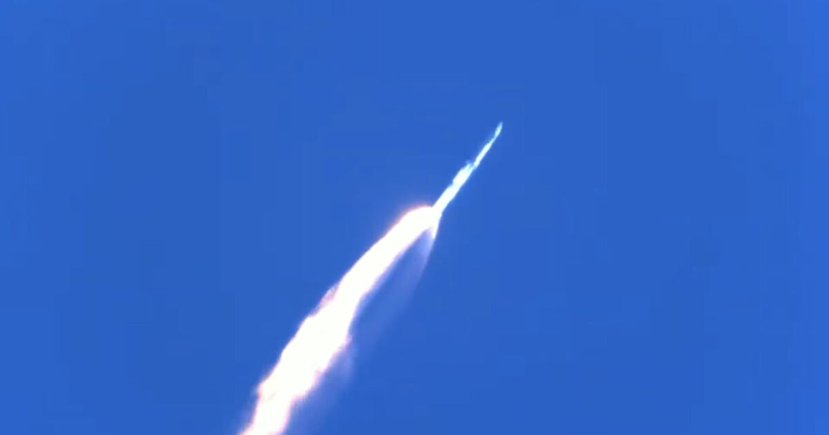SpaceX Starship and Super Heavy ascending through blue sky above the Gulf