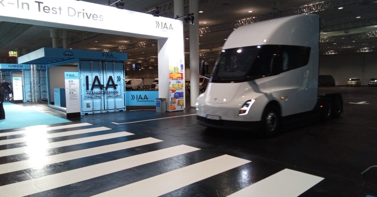 Silver Tesla Semi driving through the IAA Transportation indoor test area