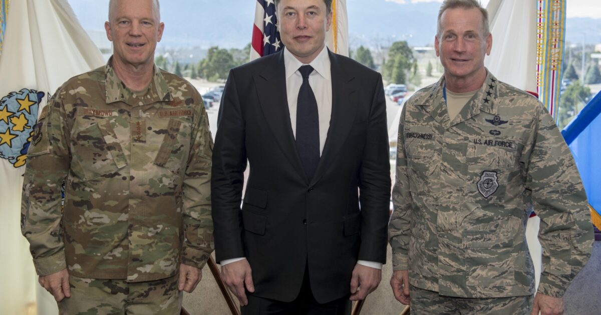 Official U.S. Air Force photo of Elon Musk standing with two senior American space and homeland-defense commanders