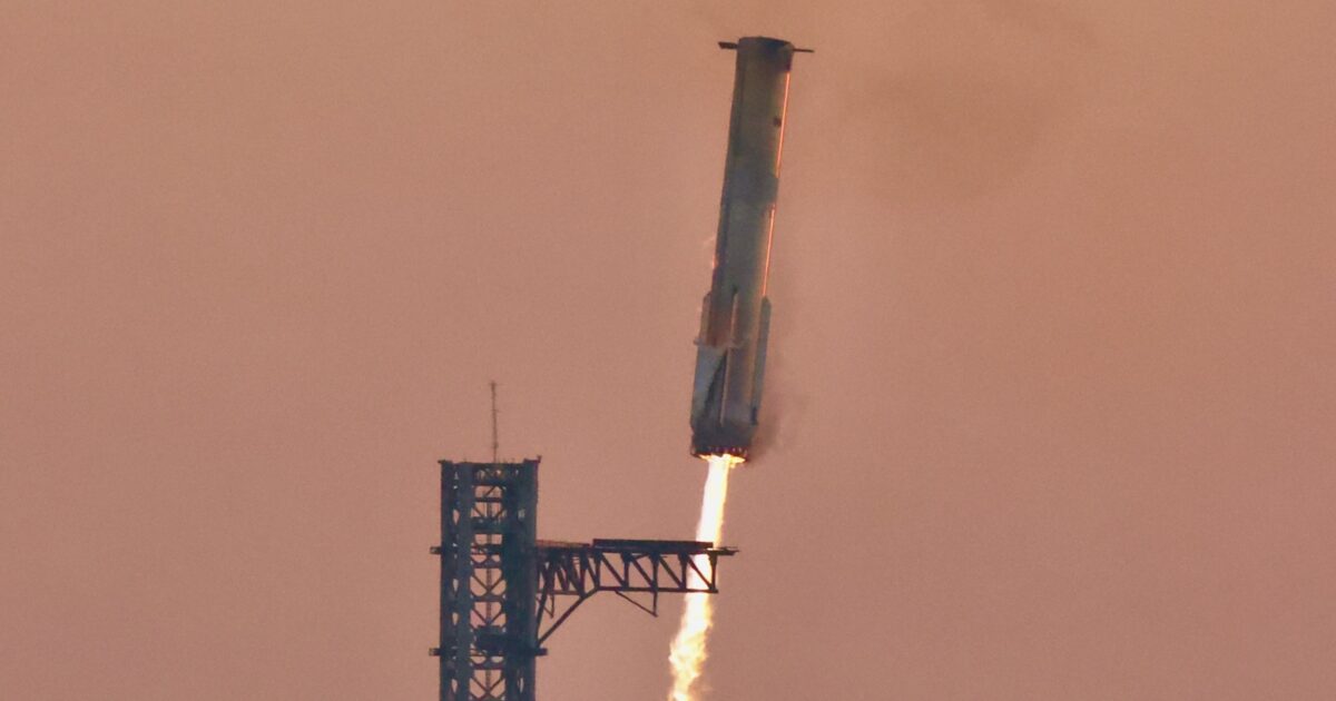 Super Heavy booster descending beside the Starbase launch-and-catch tower
