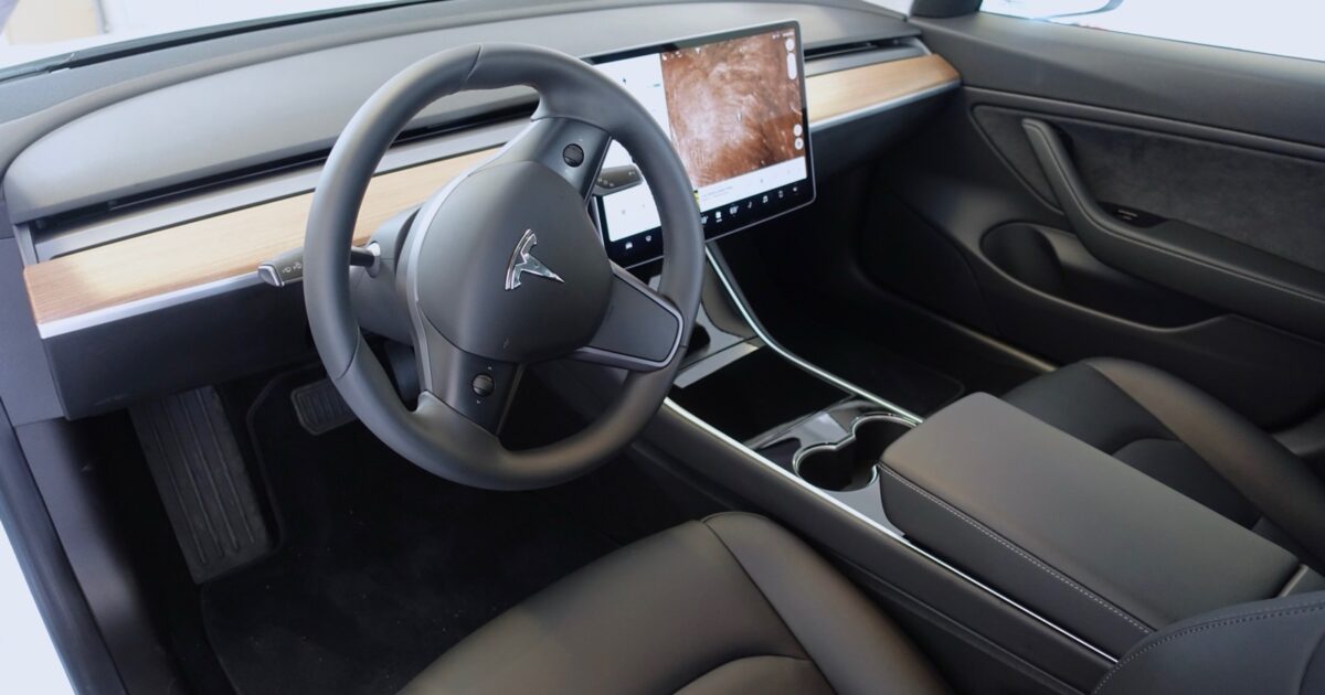 Tesla Model 3 interior with steering wheel and central touchscreen