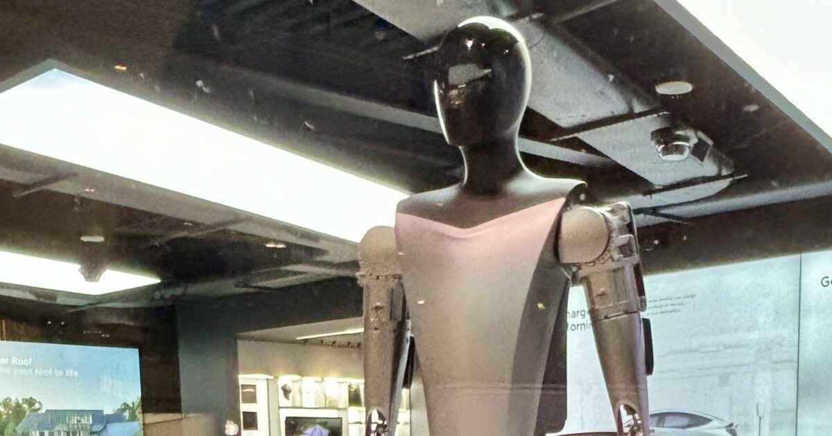 Tesla Optimus humanoid robot displayed inside a Tesla showroom